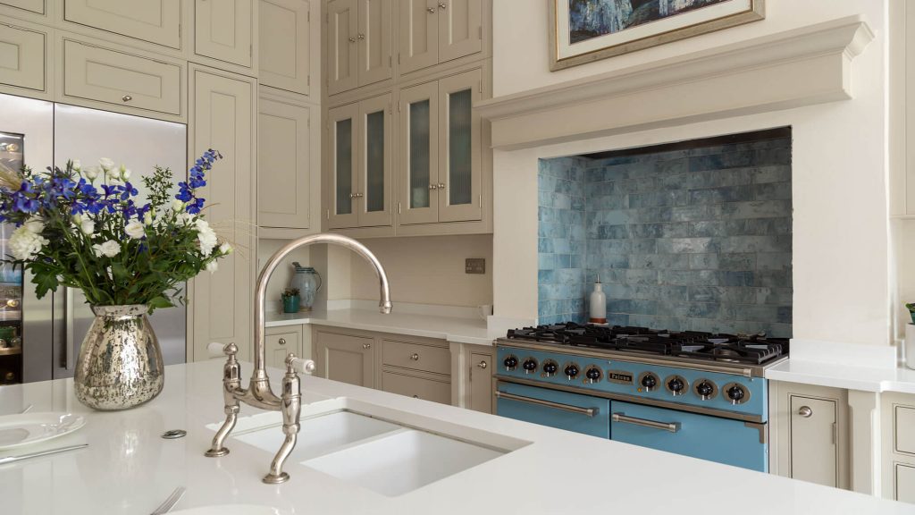 Gentle calming blue cooker in a Georgian kitchen surrounded by Georgian-style cabinetry with integrated fridge, freezer and wine cooler.