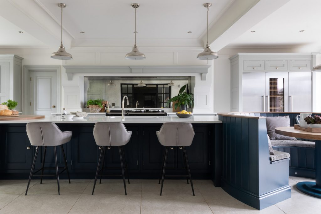 Large blue island with a seating area and quartz worktop in a kitchen