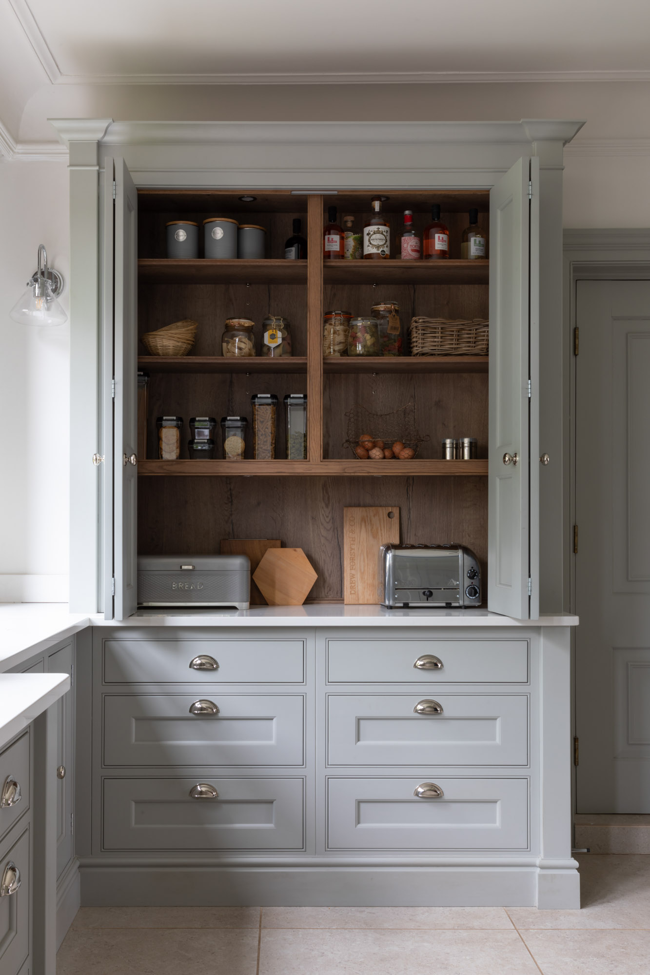 open fitted kitchen cabinetry larder breakfast bar with drawers and bi-fold doors in white paint